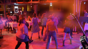 Line-Dance-Publikum bei einem Live-Auftritt der österreichischen Country Band Boots On!, während sie vor der Bühne in einer Konzertlocation tanzen.